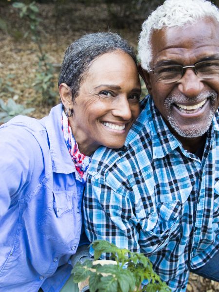 An attractive senior black couple working in the garden taking a selfie with their smartphone